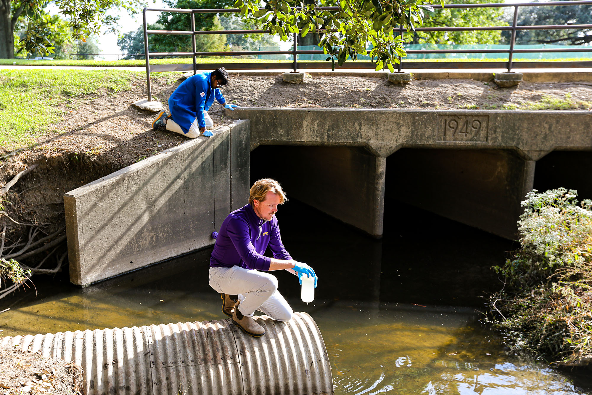Aaron Bivins collects water samples with a team member.
