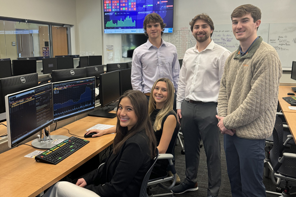 Students on the victorious Bloomberg trading challenge team gather around computers in the LSU SMART Lab.